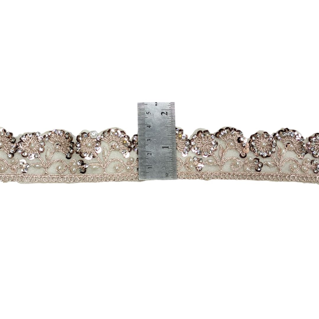 Decorative lace trim with a ruler for scale on a white background