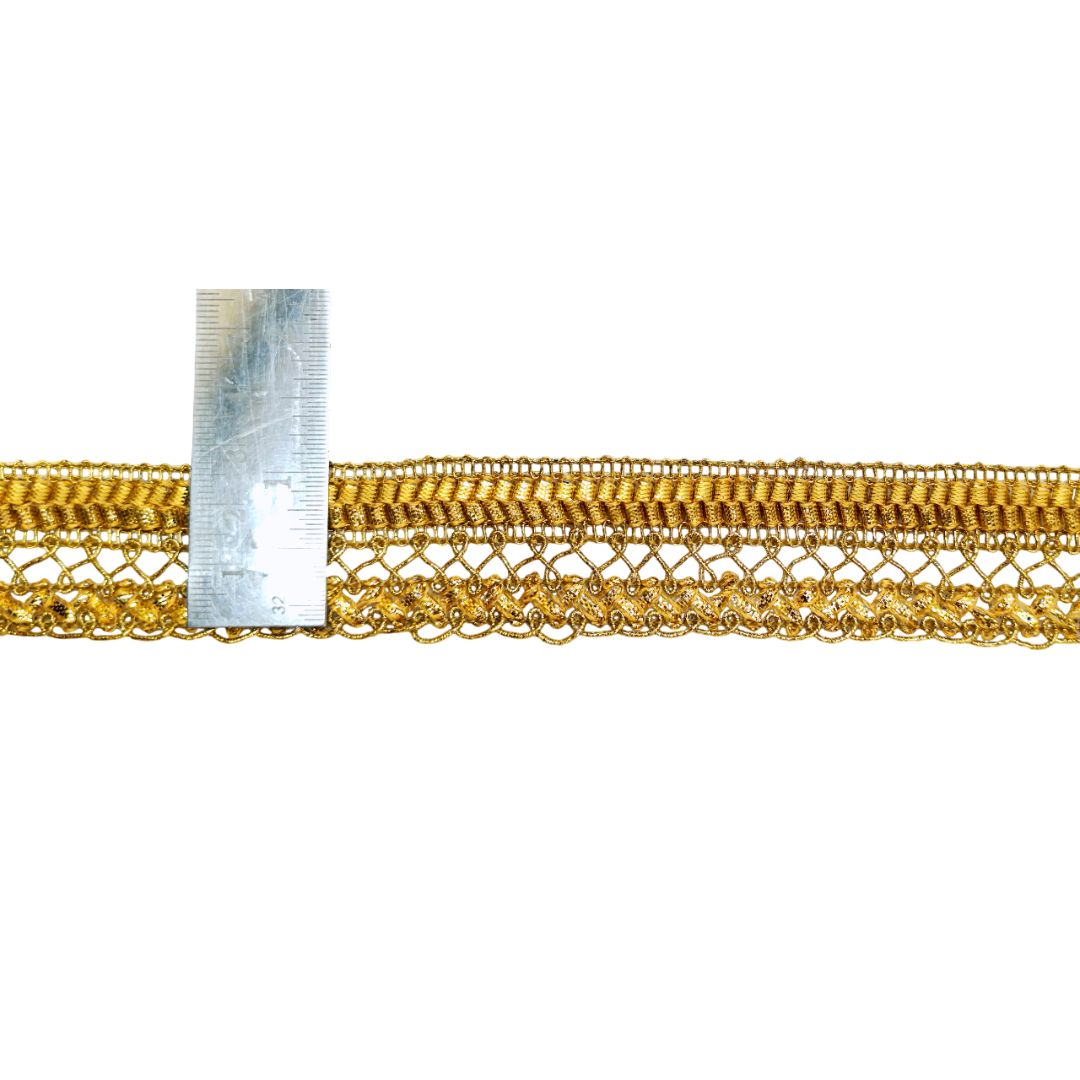 Gold lace trim with a ruler for scale on a white background