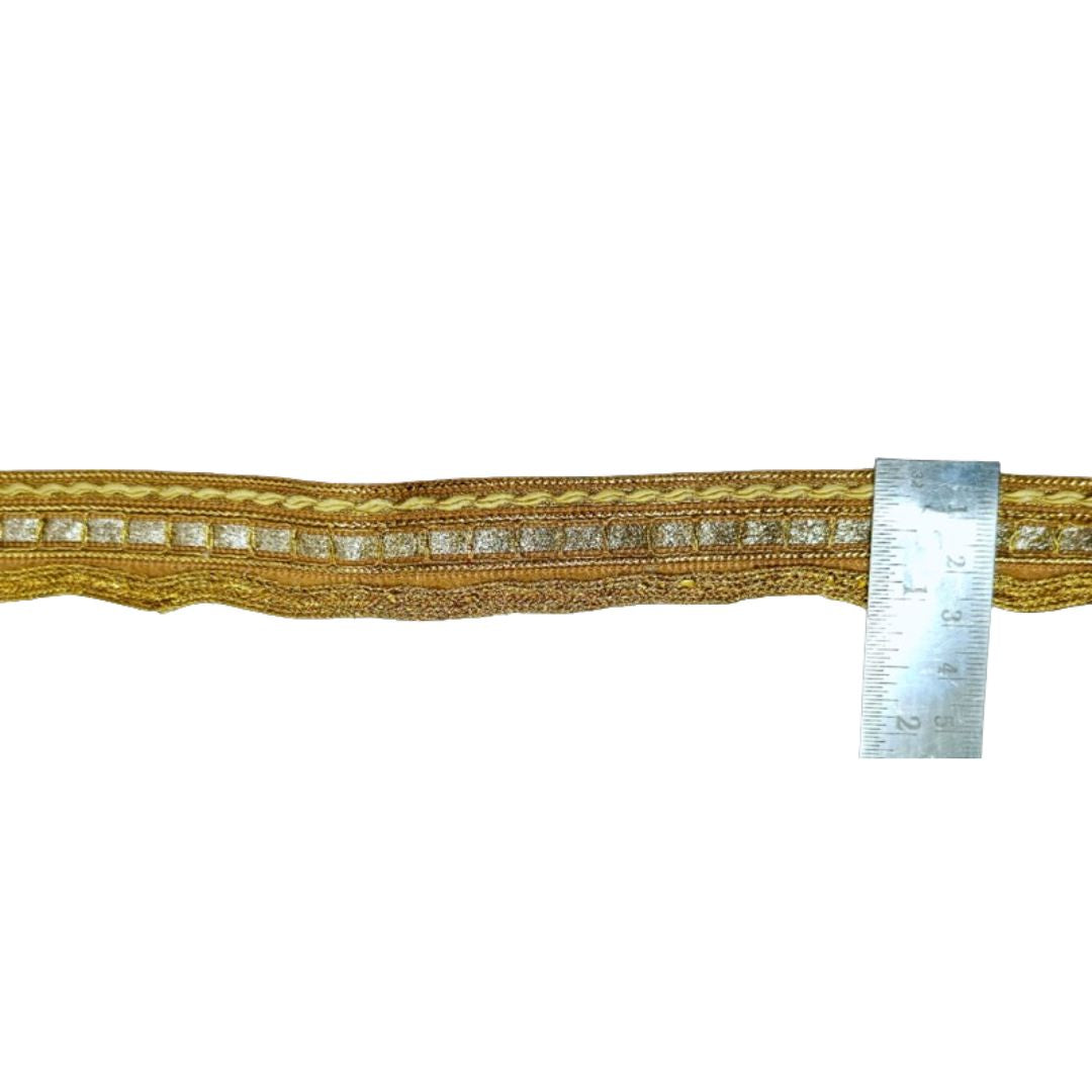 Gold braided cord with a ruler for scale on a white background