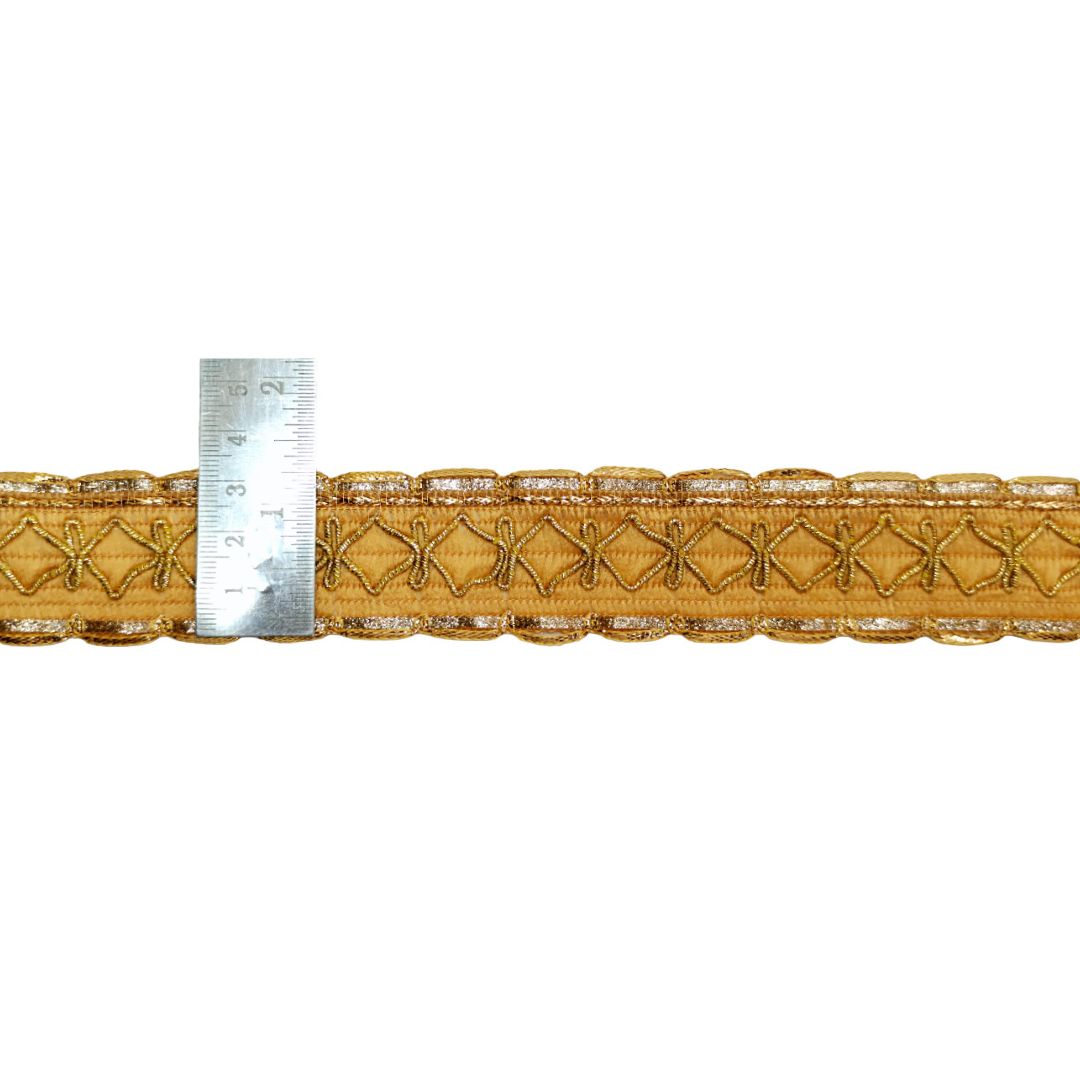 Gold lace trim with a ruler for scale on a white background