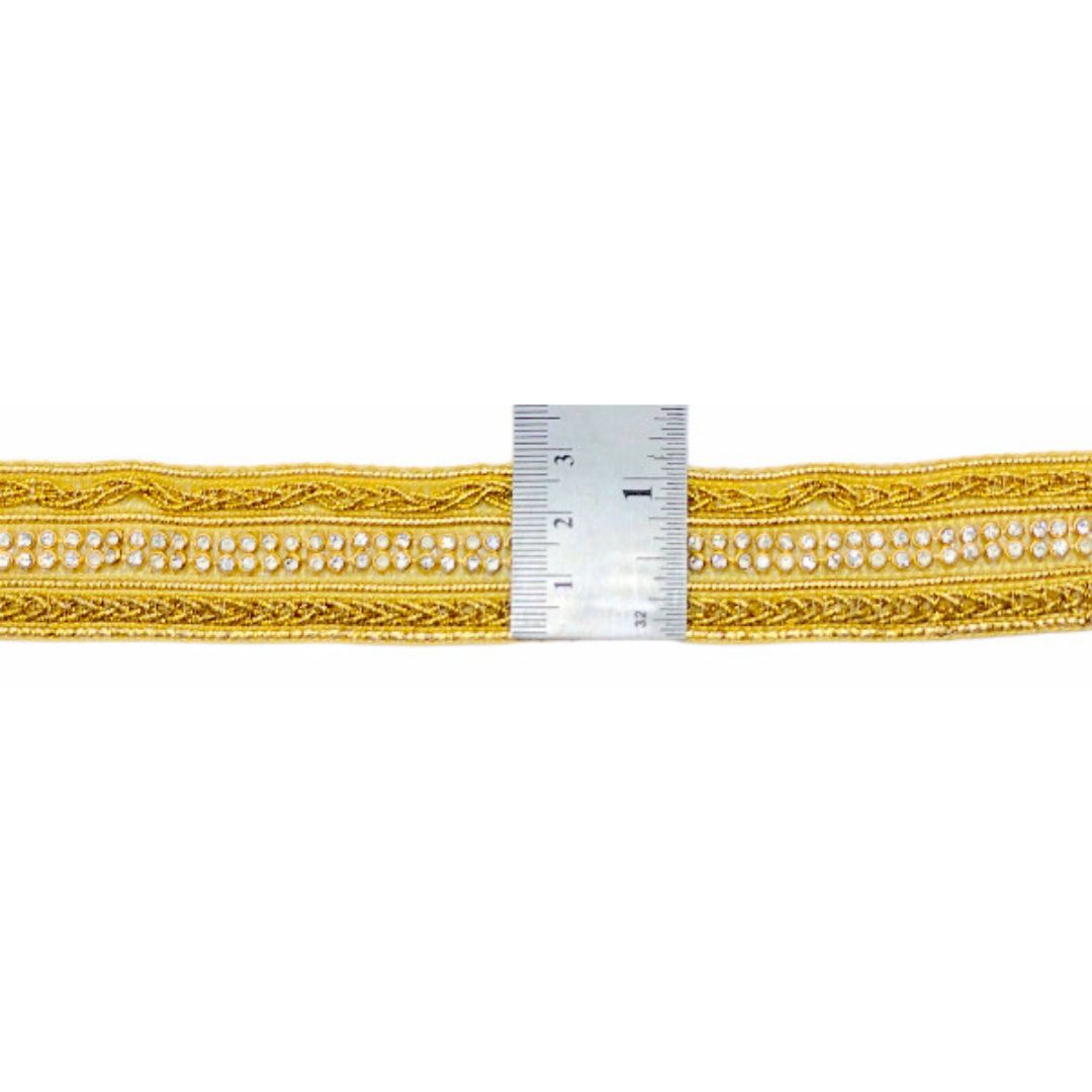 Gold braided trim with a ruler for scale on a white background