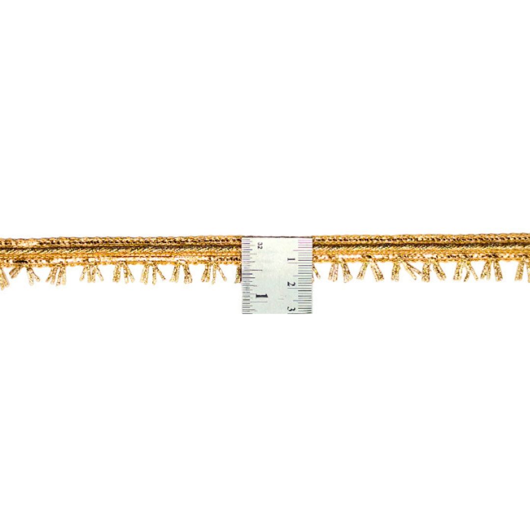 Gold fringe trim with a ruler for measurement on a white background