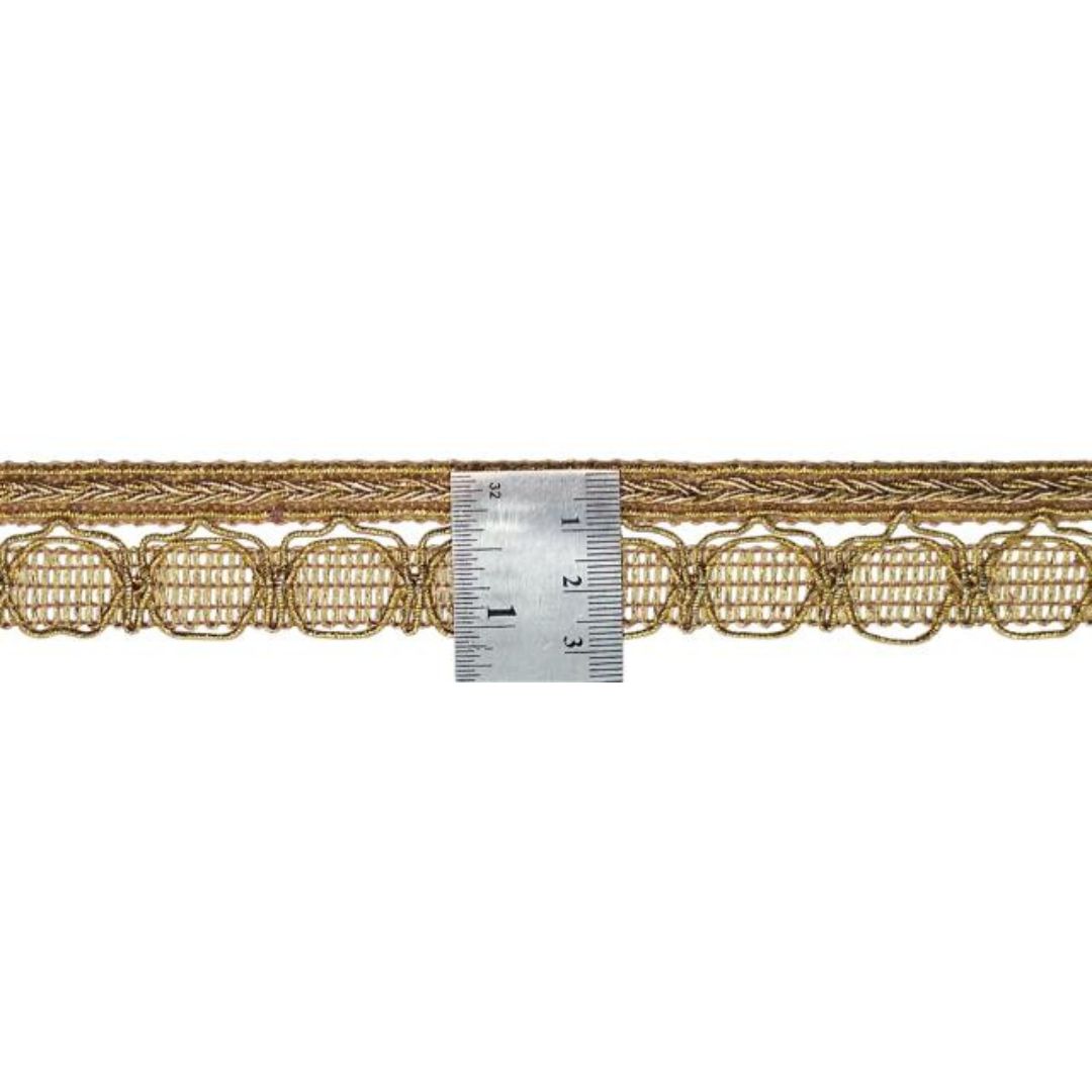 Decorative gold lace trim with a ruler for scale on a white background