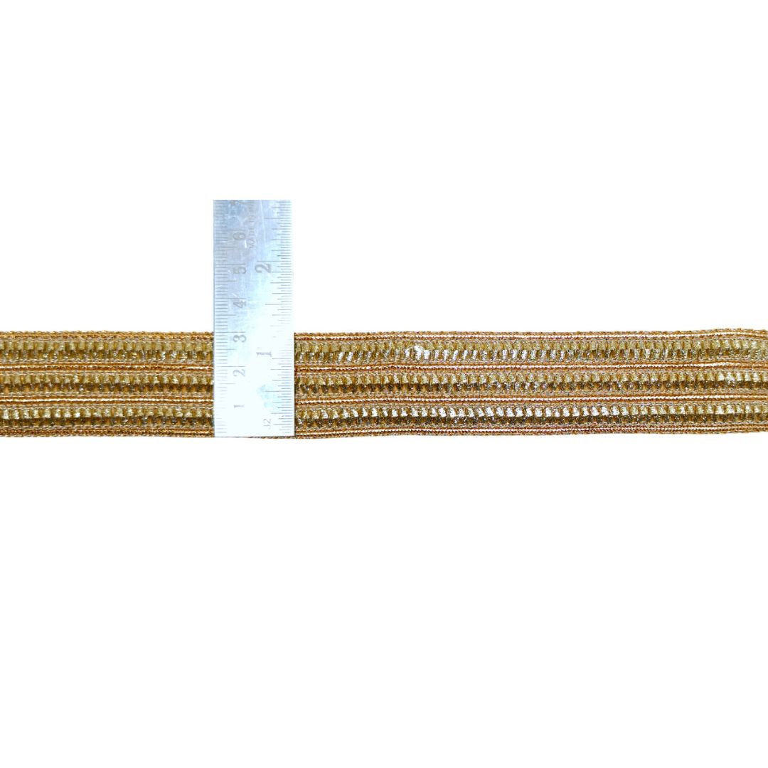Gold-colored cord with a ruler for scale on a white background