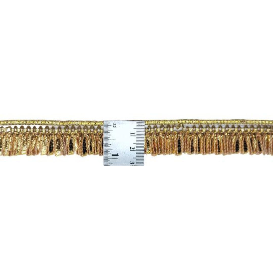 Gold fringe trim with a ruler for scale on a white background