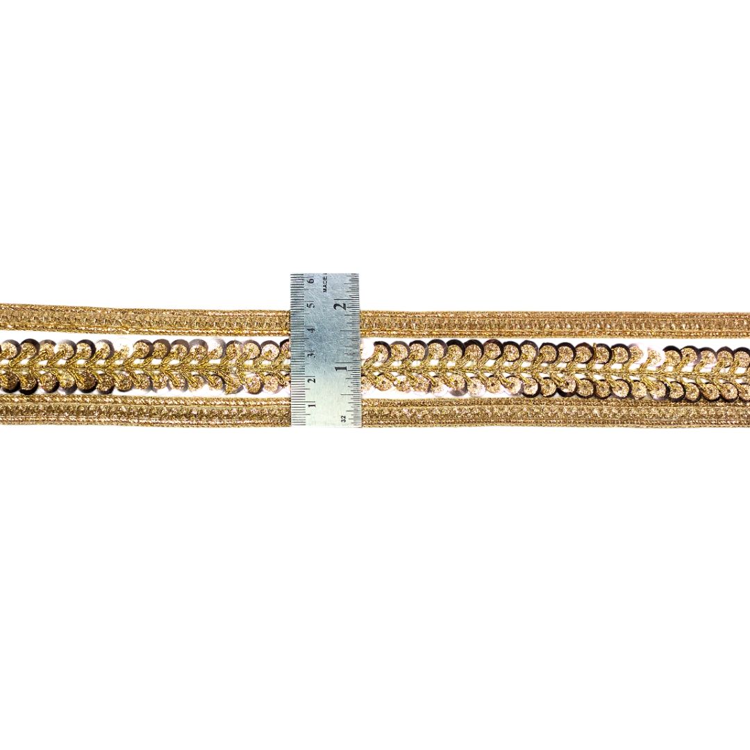 Gold braided cord with a ruler for scale on a white background