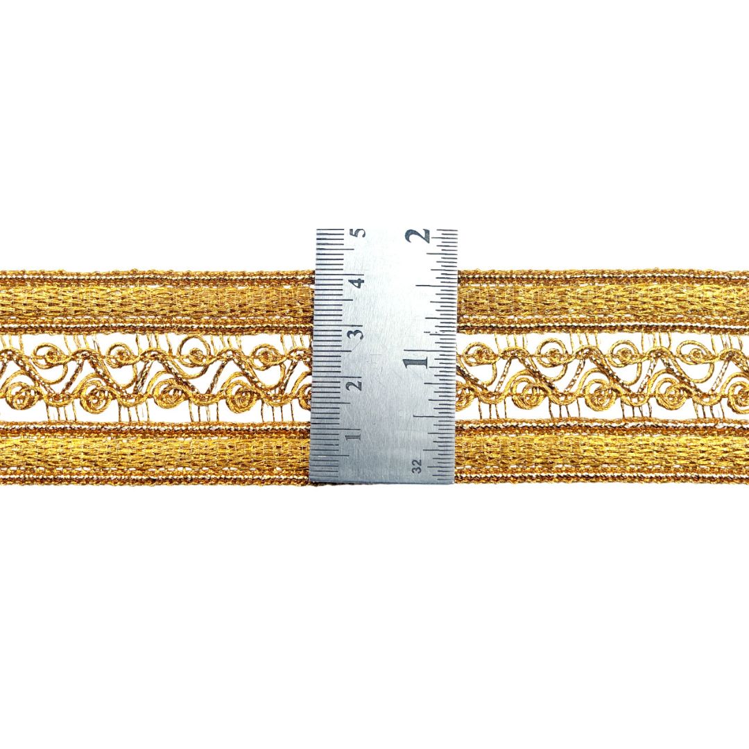 Gold lace trim with a ruler for scale on a white background