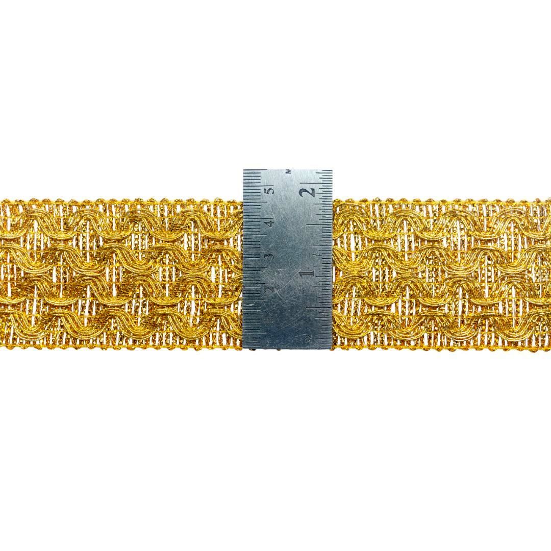Gold braided trim with a ruler for scale on a white background