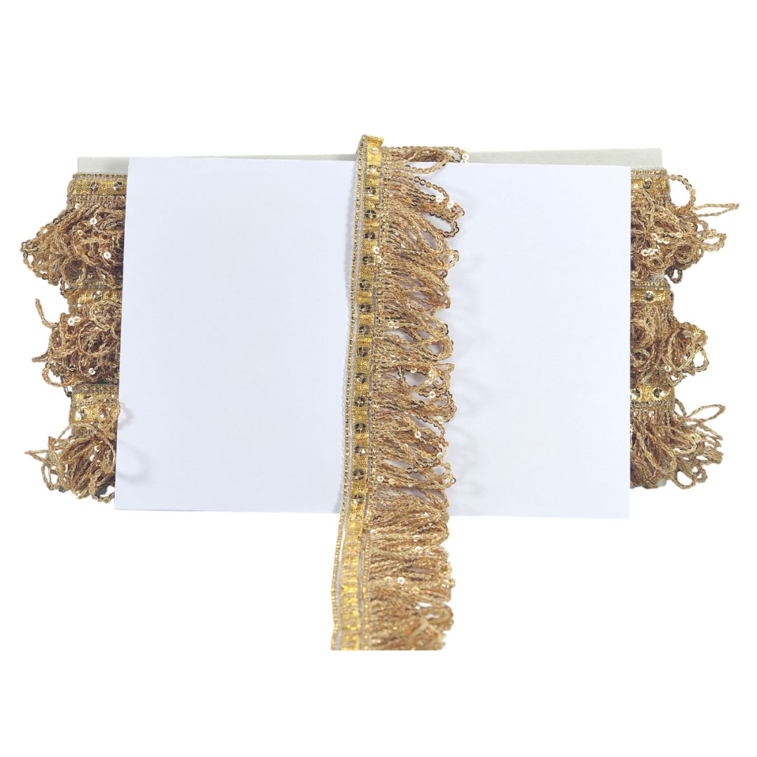 Gold fringe trim on a white background