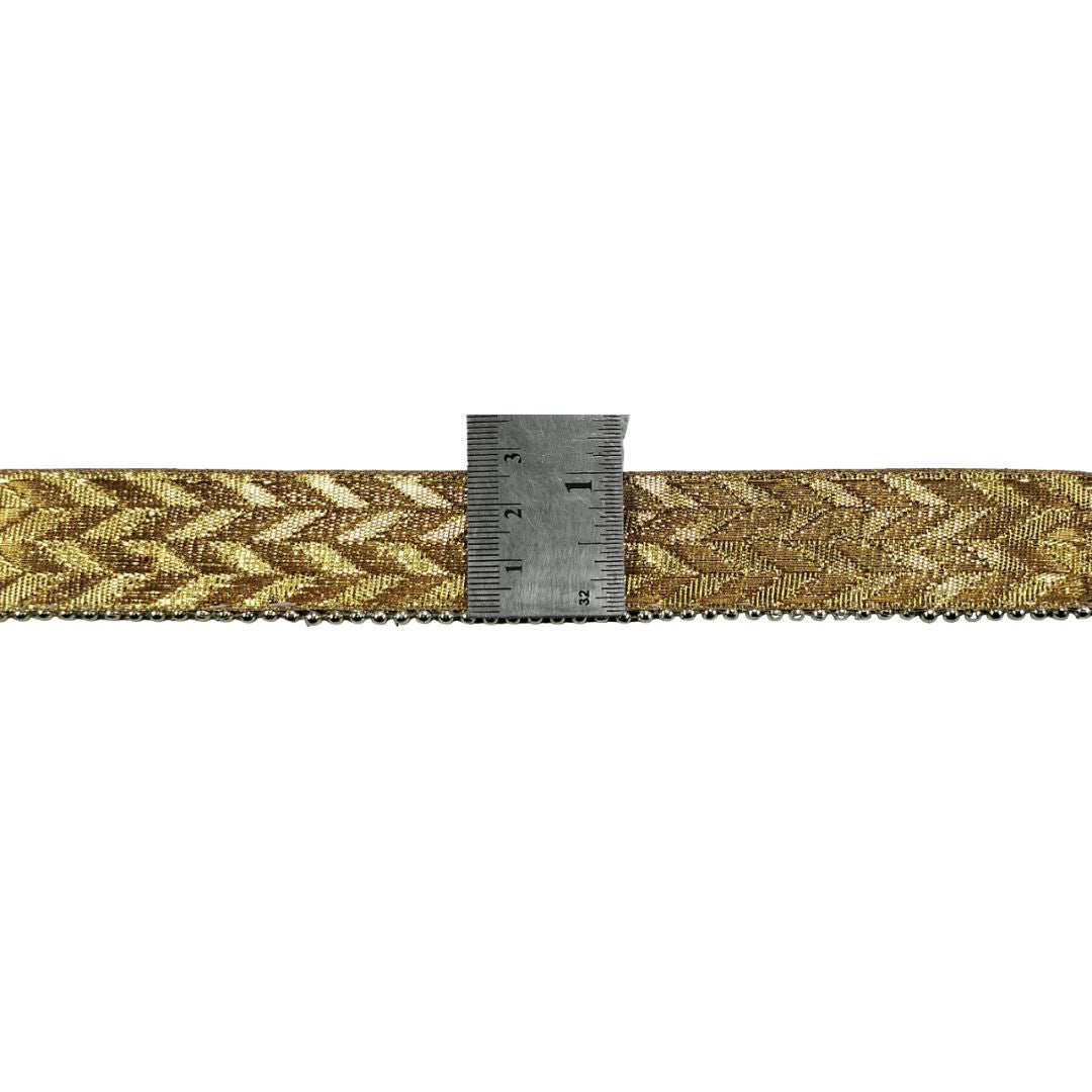 Gold woven belt with a ruler for scale on a white background