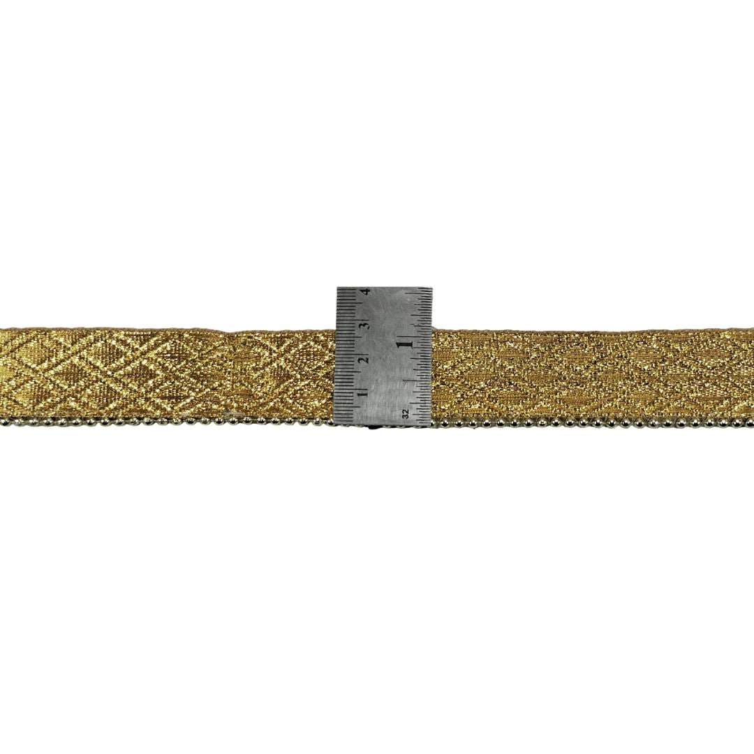Gold woven belt with a ruler for scale on a white background