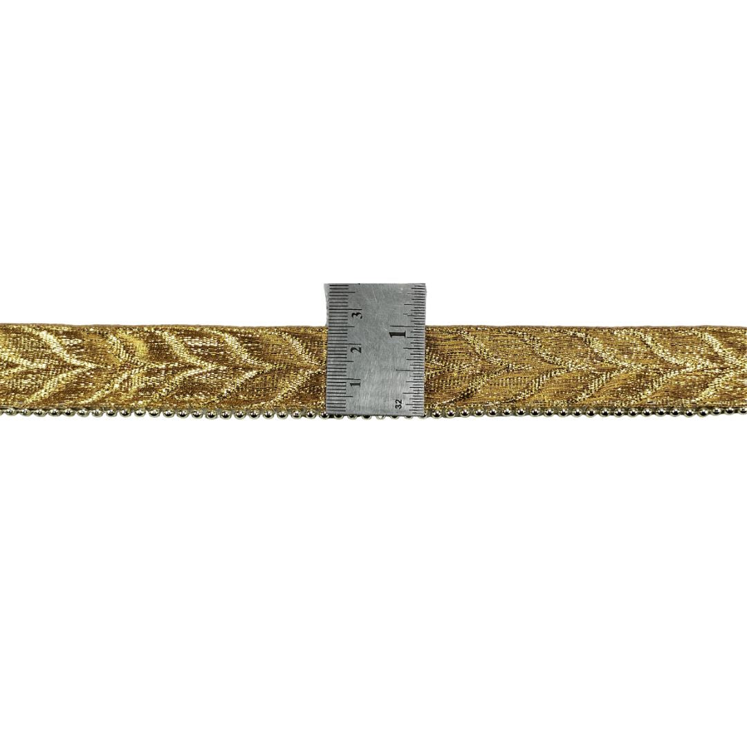 Gold woven ribbon with a ruler for scale on a white background