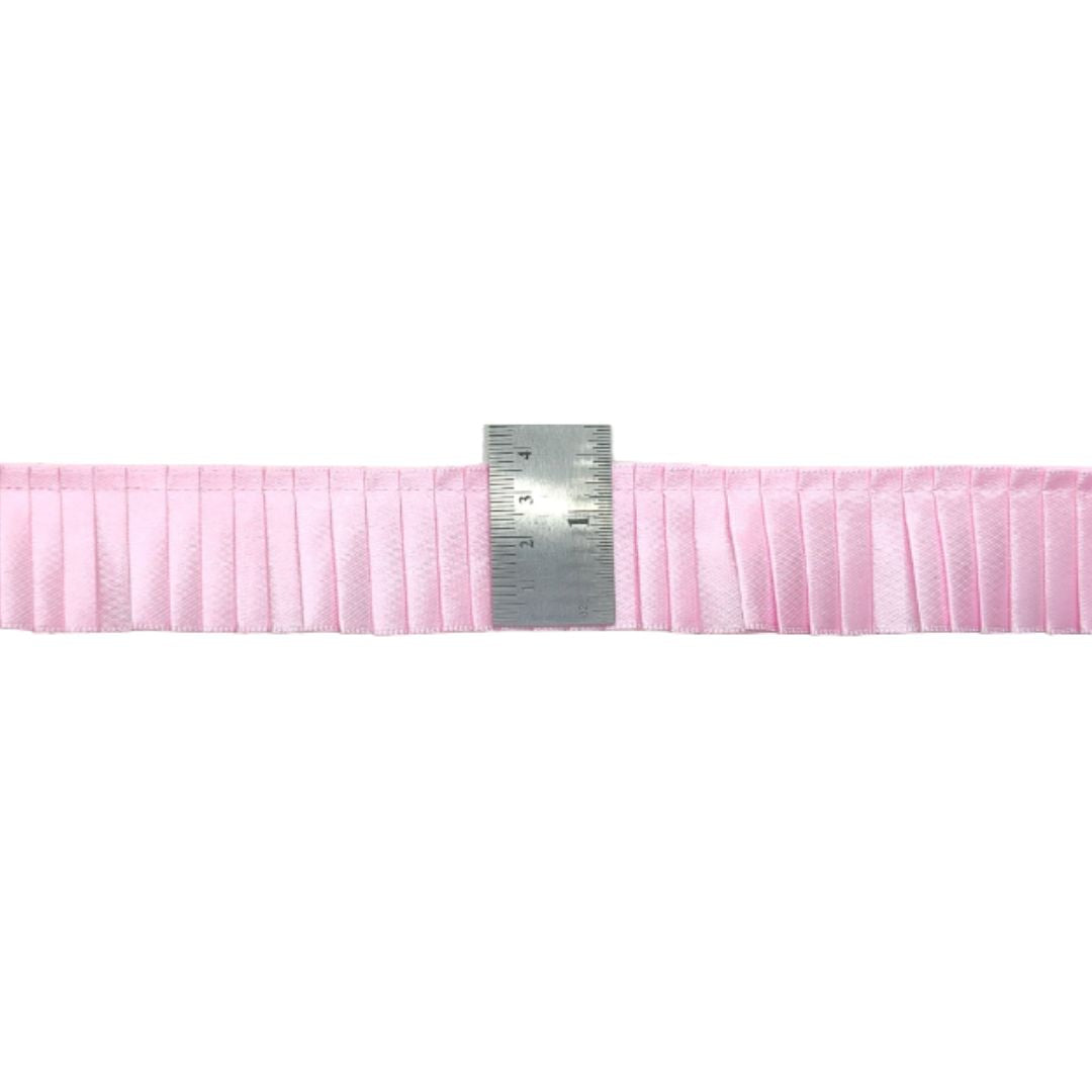 Pink ribbons with a ruler for scale on a white background