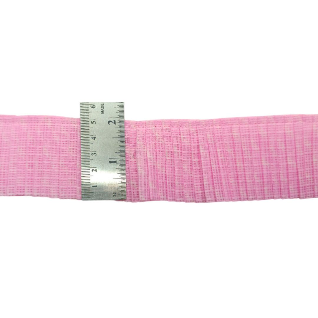 Roll of pink mesh fabric with a metal ruler for scale on a white background