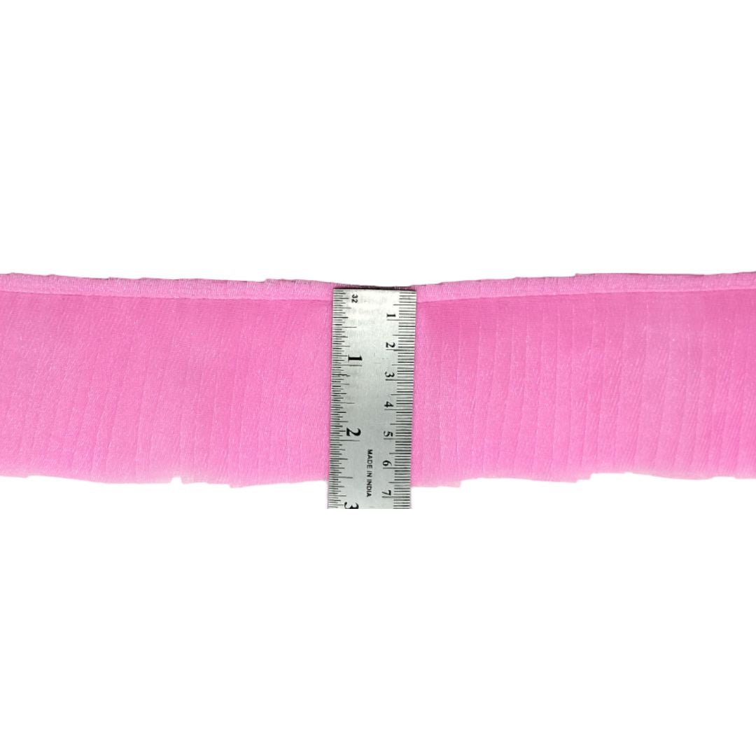 Pink ribbon with a ruler for measurement on a white background
