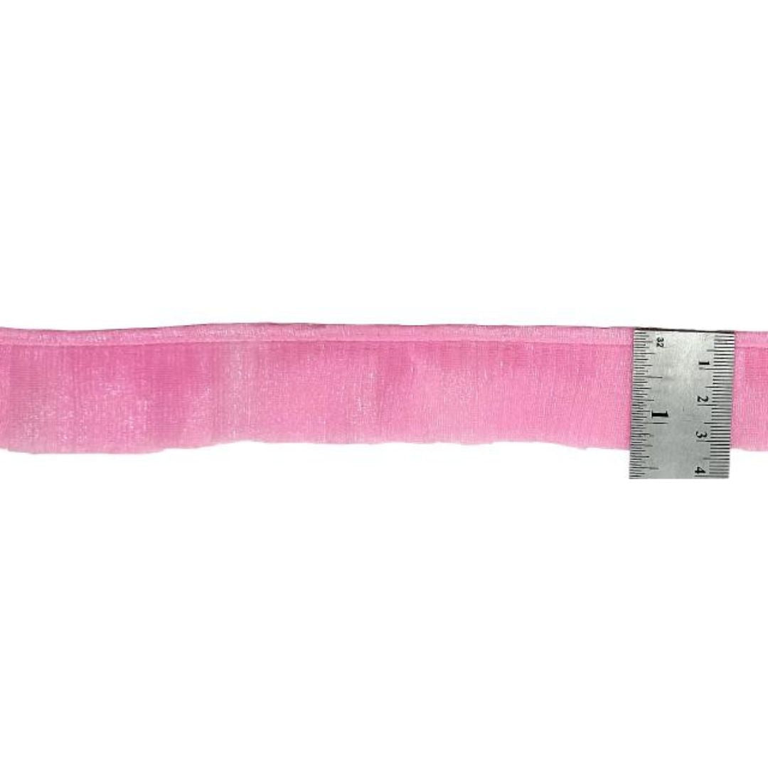 Pink ribbon with a ruler for measurement on a white background