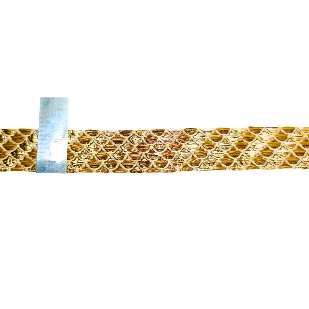 Gold metallic ribbon with a ruler for scale on a white background