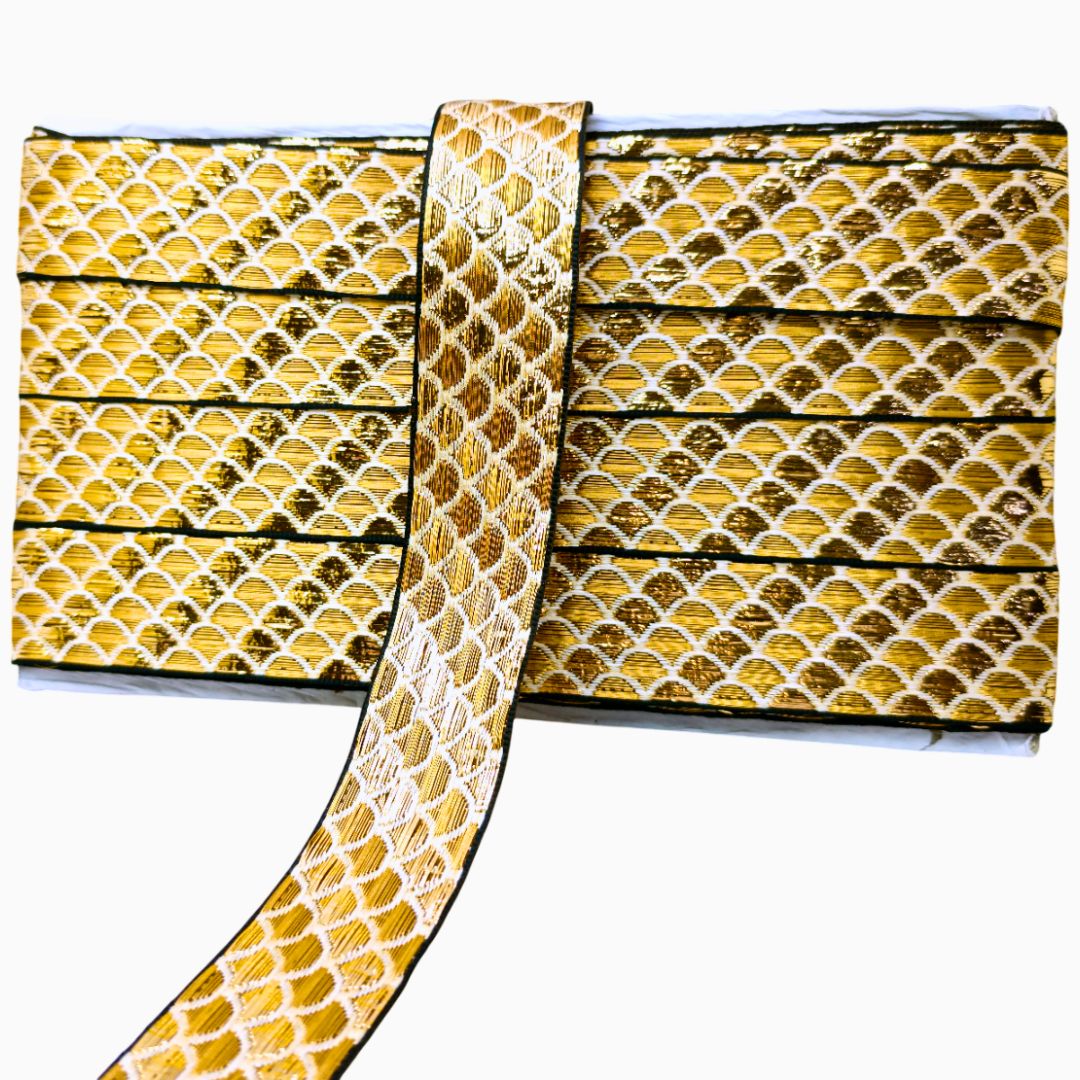 Gold and black patterned fabric with a decorative ribbon on a white background