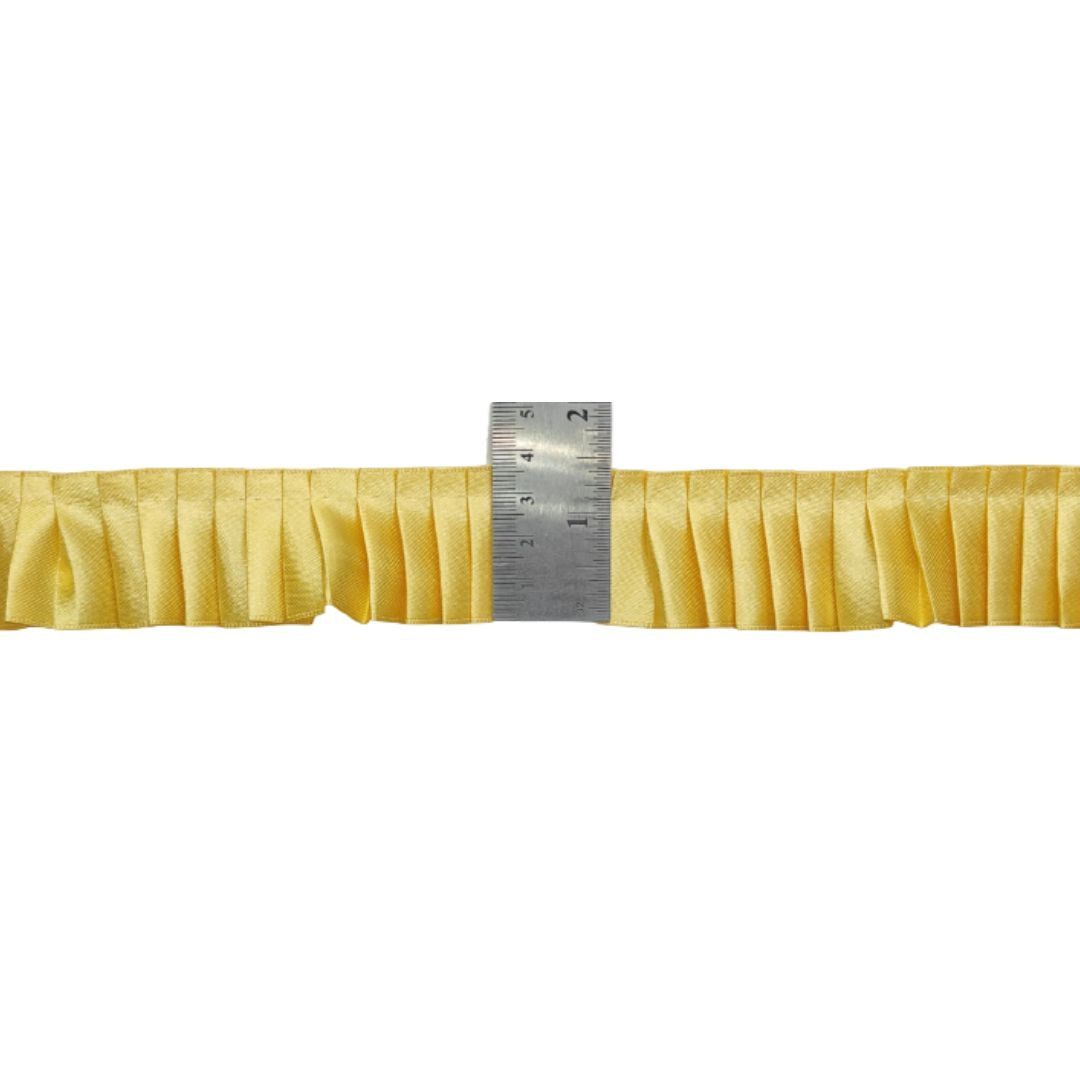 Yellow fabric with a ruler showing measurements on a white background