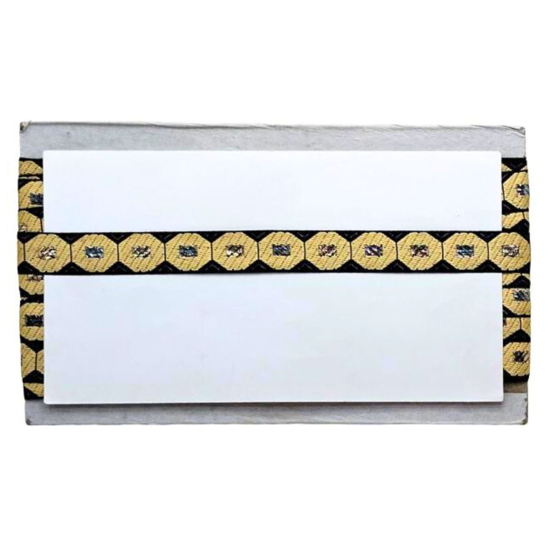 Clutch bag with gold and black patterned flap on a white background