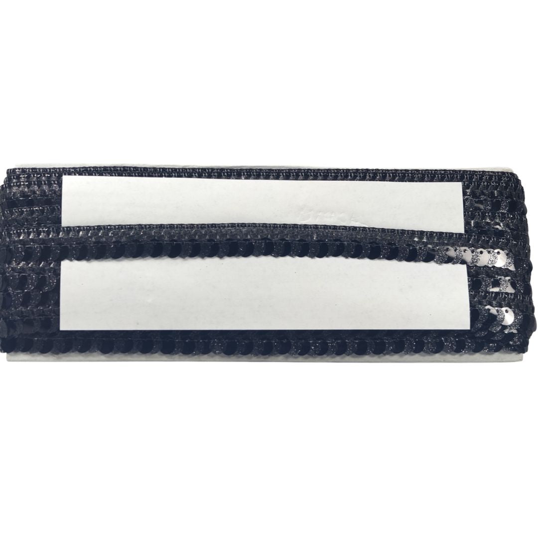 Black sequined clutch with two white straps on a white background