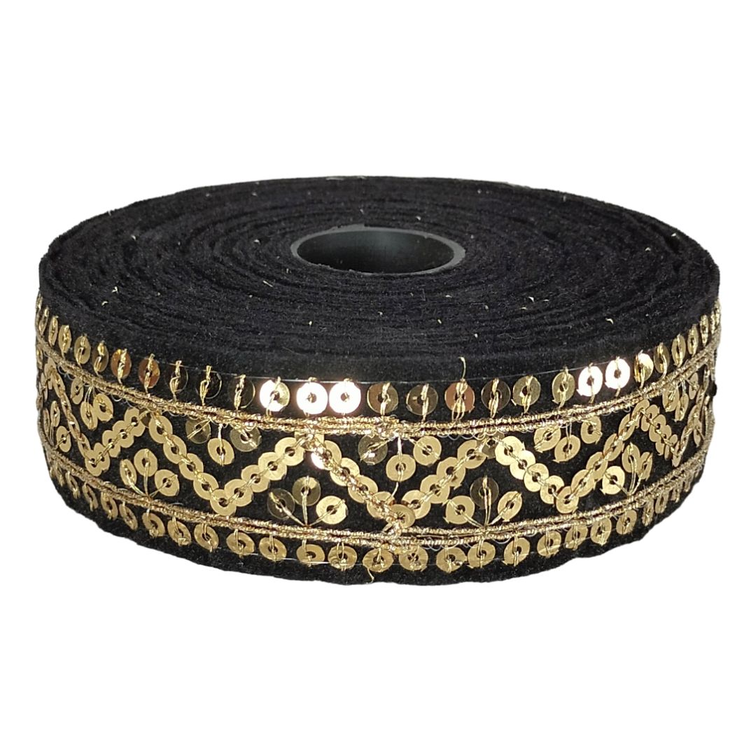 Roll of black ribbon with gold sequin detailing on a white background