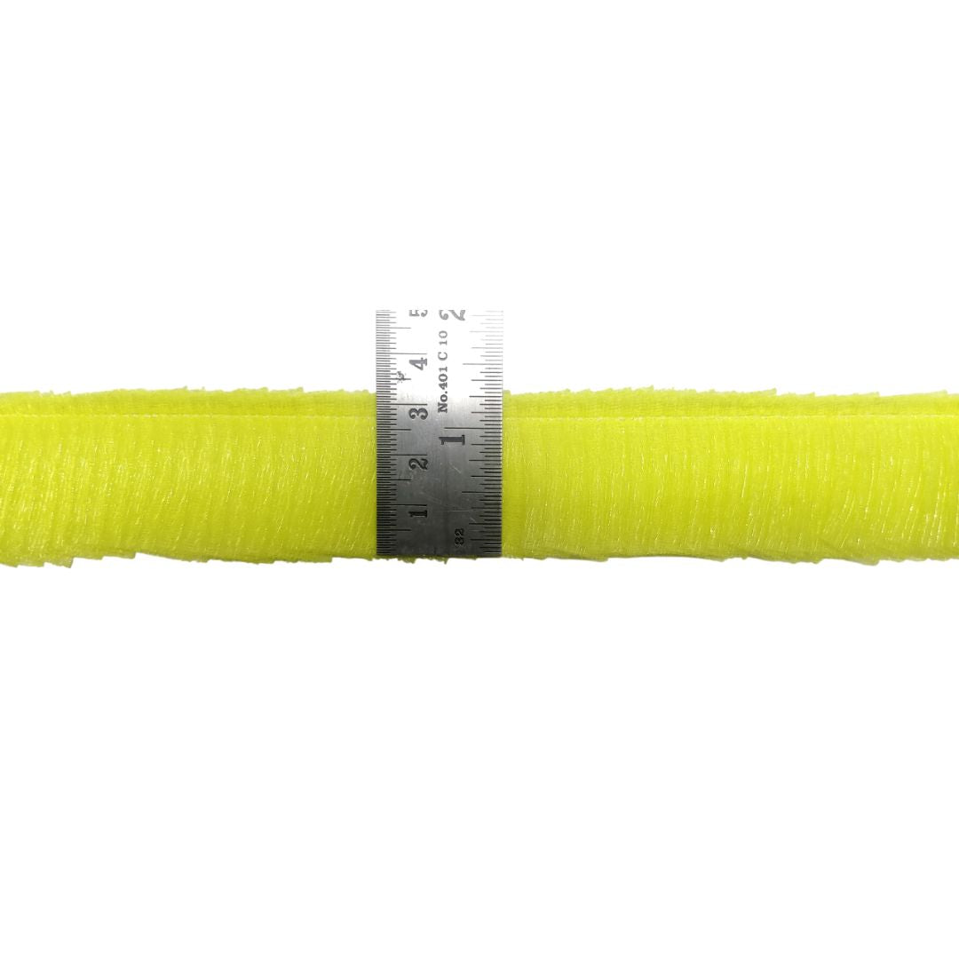Yellow hose with a ruler for scale on a white background