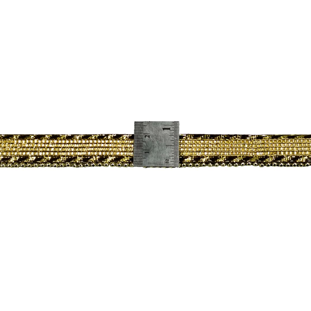 Gold and black patterned belt with a ruler for scale on a white background