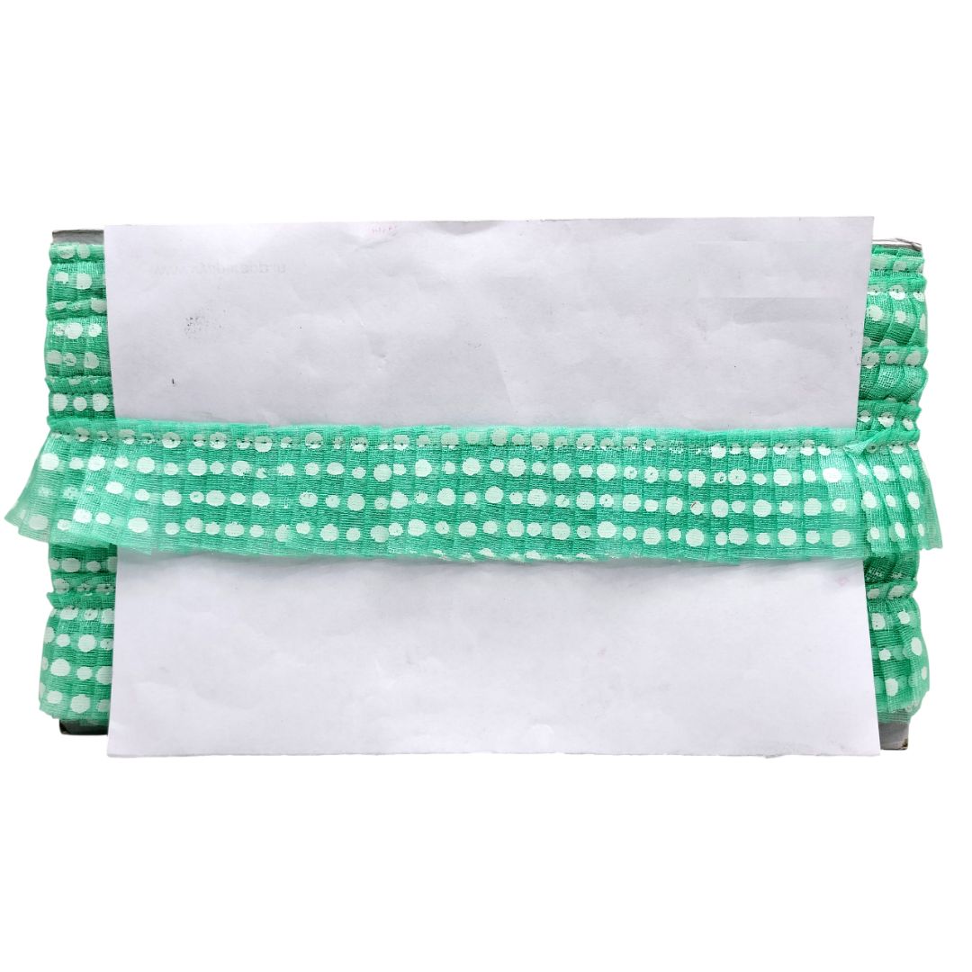 Green and white polka dot clutch bag on a white background