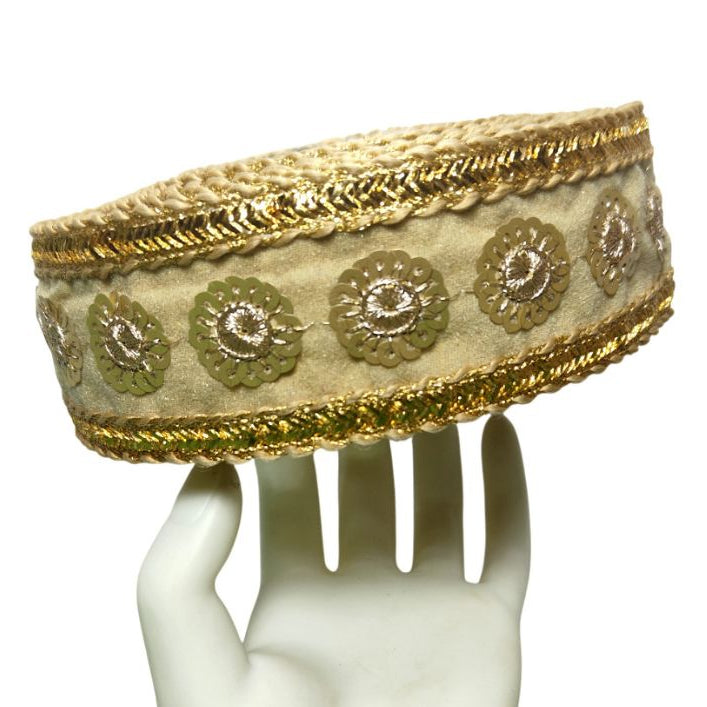 Decorative headband with gold and beige patterns on a mannequin head.