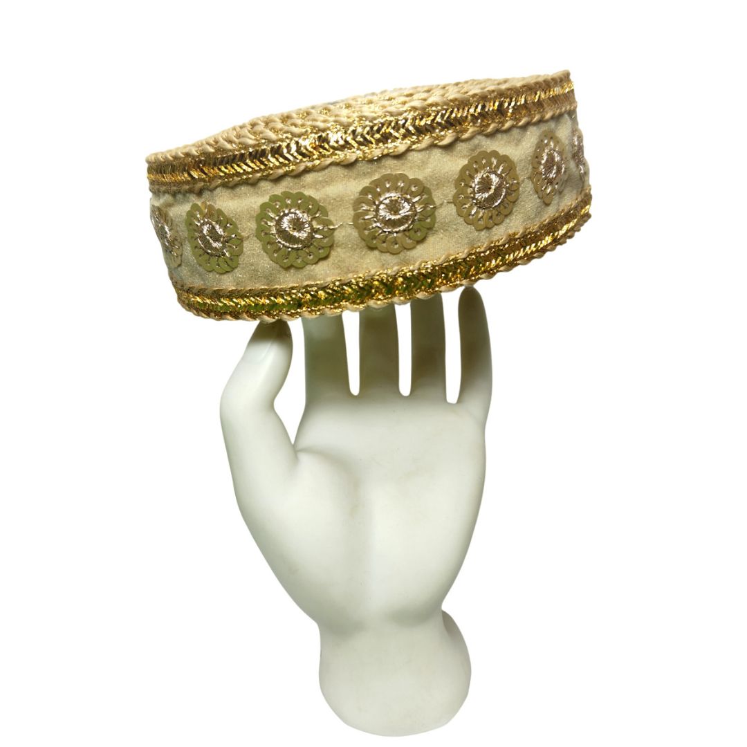 Decorative headband with gold and beige patterns on a mannequin head.