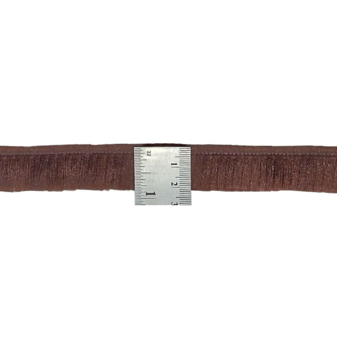 Brown belt with a ruler for scale on a white background