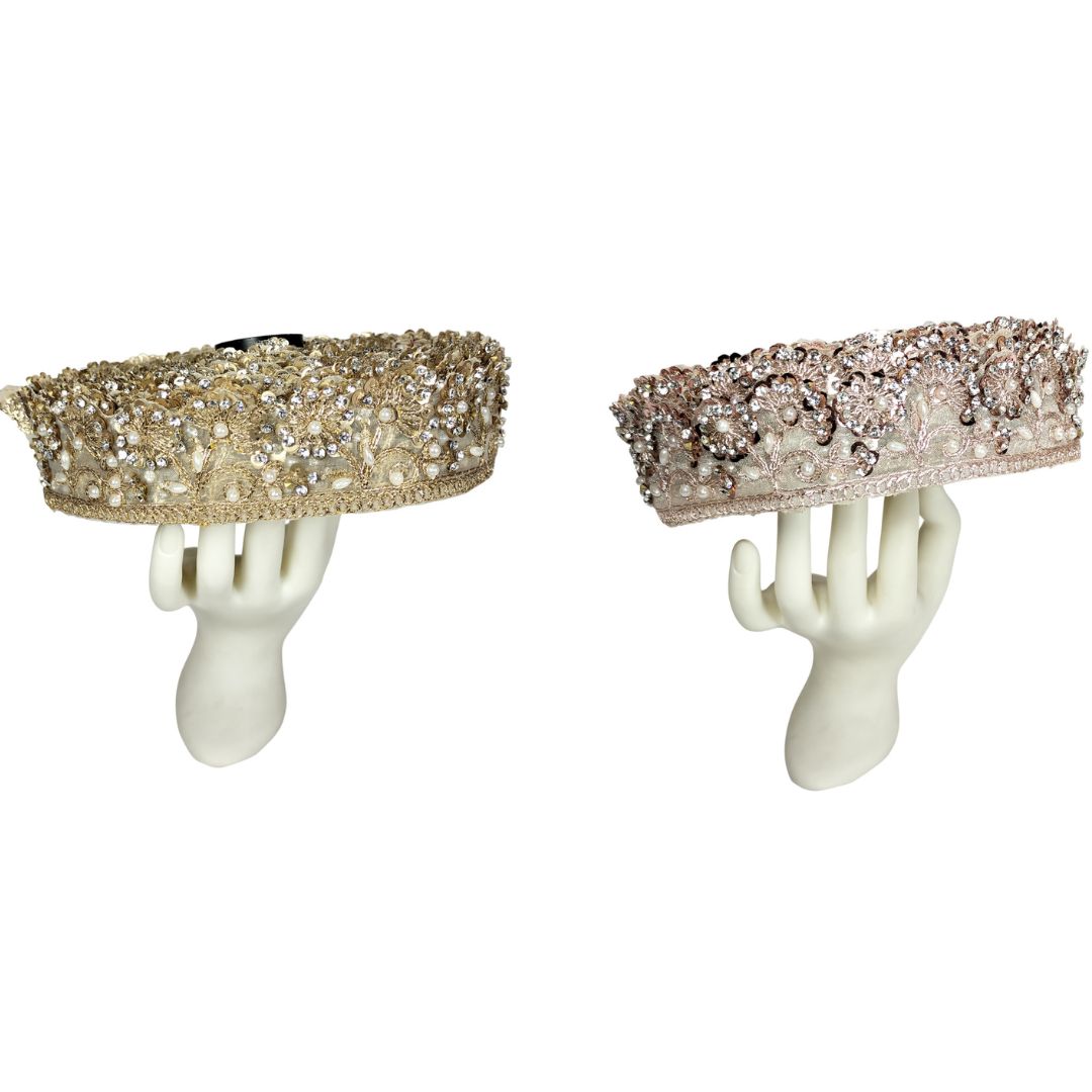 Two decorative items on mannequin hands against a white background