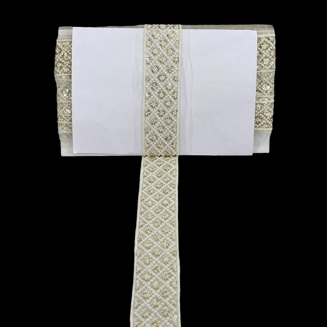 White fabric with gold embroidery on a black background
