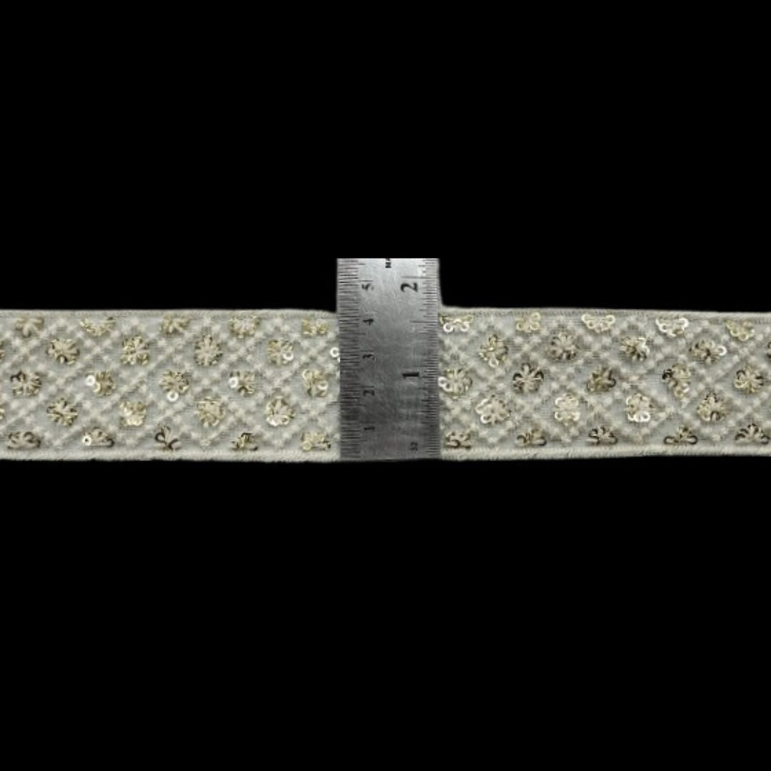 Decorative ribbon with floral pattern and a ruler for scale on a black background
