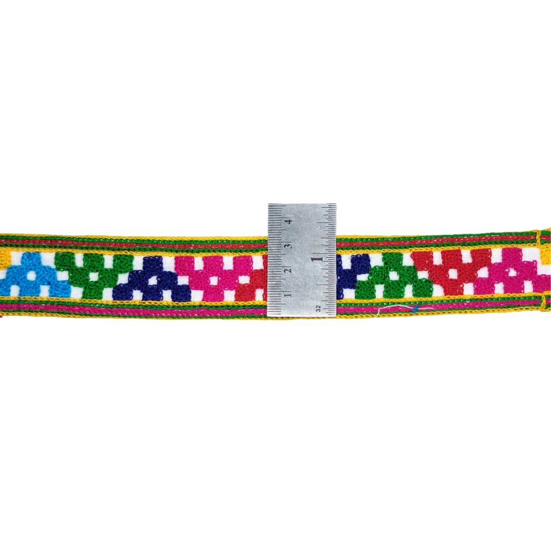 Colorful woven belt with a ruler for scale on a white background