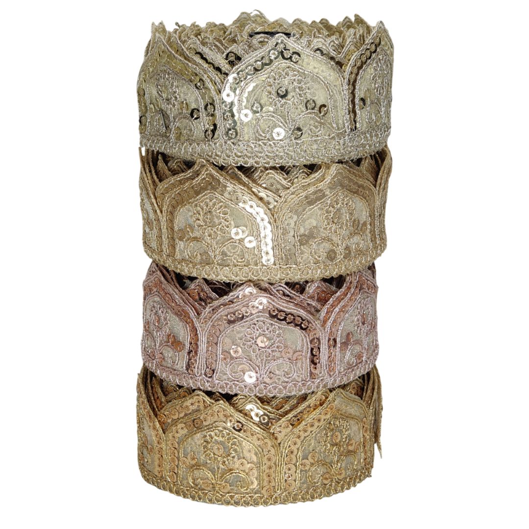 Stack of ornate, embroidered fabric rolls on a white background