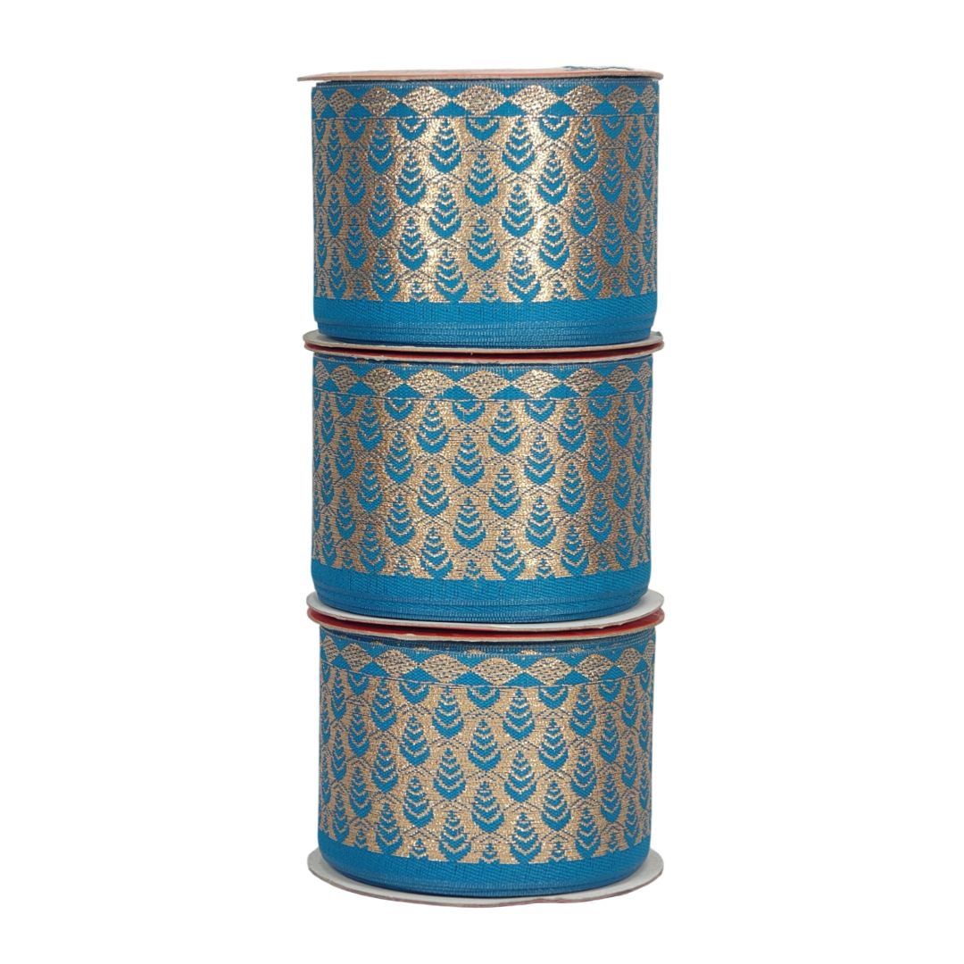 Three rolls of blue ribbon with gold patterns stacked on a white background