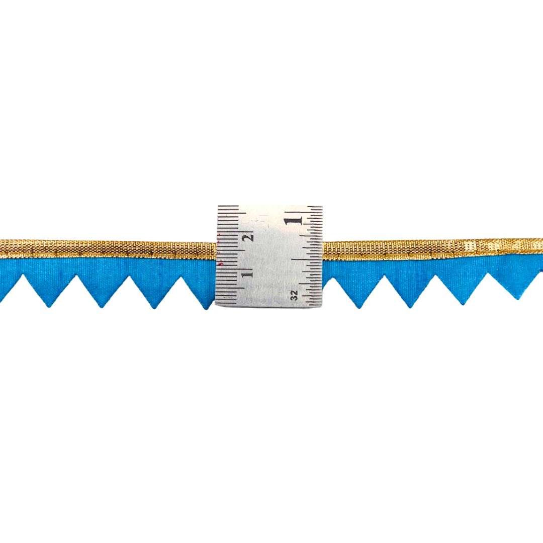 Close-up of a blue and gold zigzag pattern with a ruler for scale on a white background