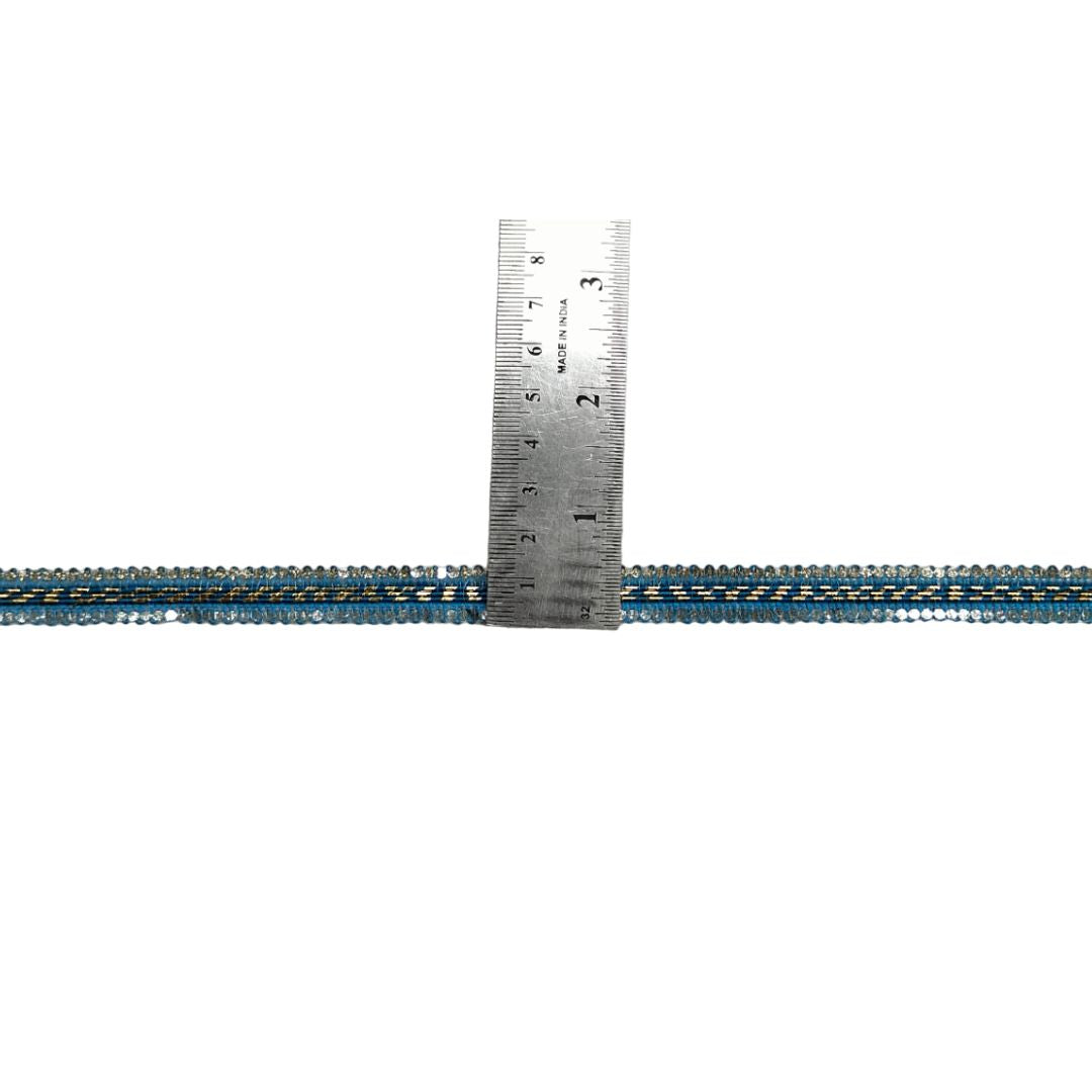Metallic blue and gold braided cable with a ruler for scale on a white background