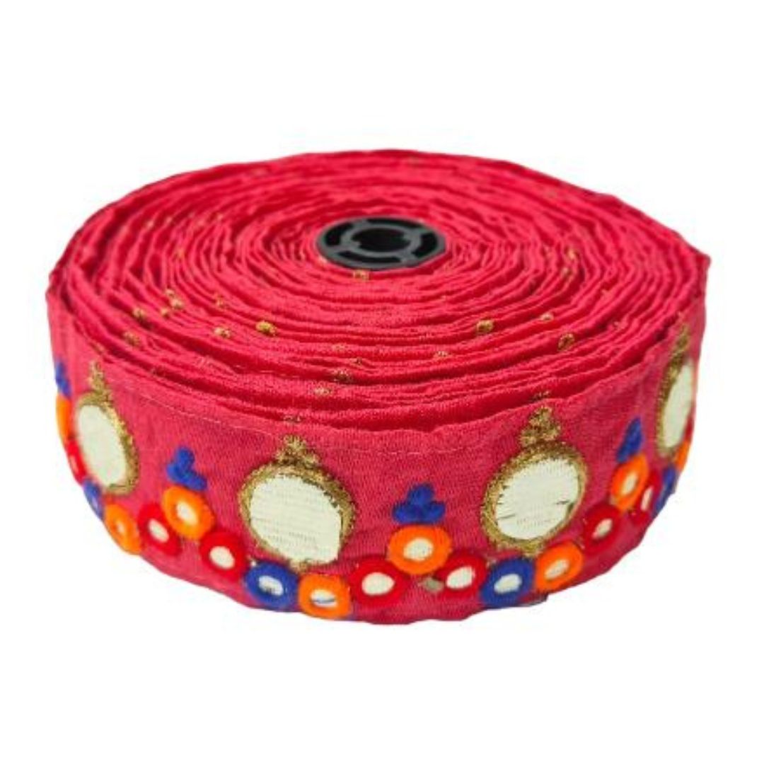 Roll of red fabric with colorful patterns on a white background