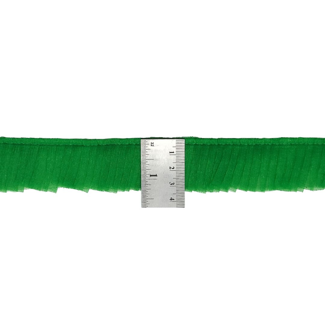 Green fringe fabric with a ruler for scale on a white background
