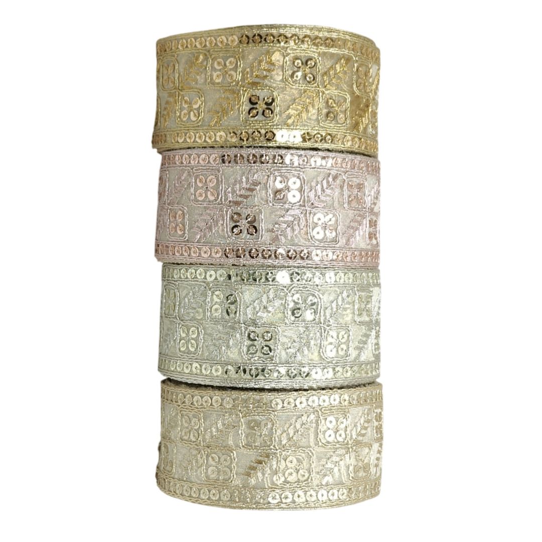 Set of four ornate metal bangles stacked on a white background