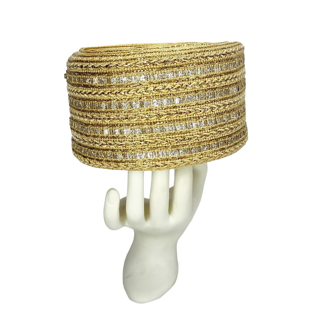 Gold beaded bracelet on a white mannequin arm against a white background