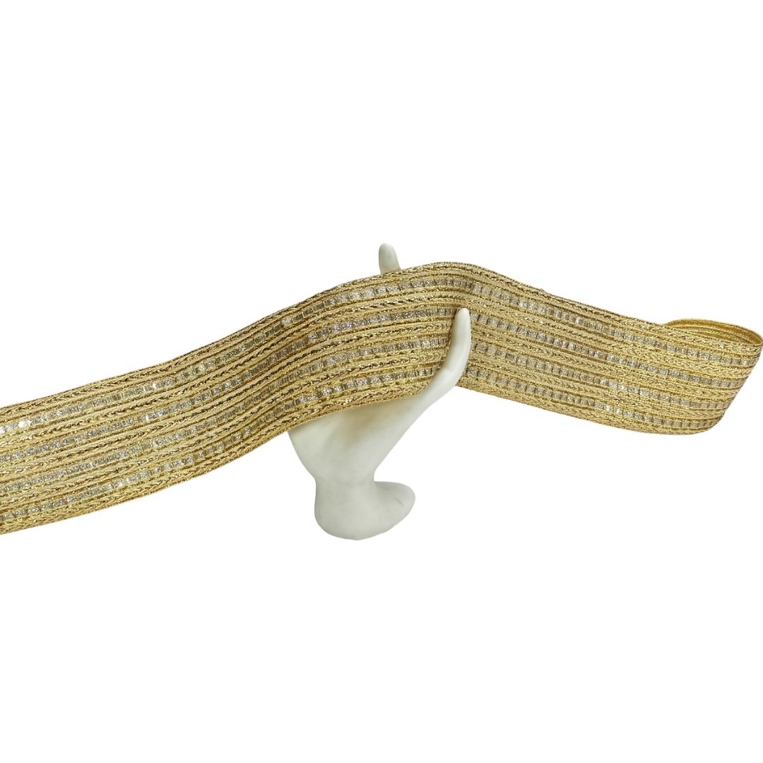 Gold ribbon with rhinestones on a white stand against a white background