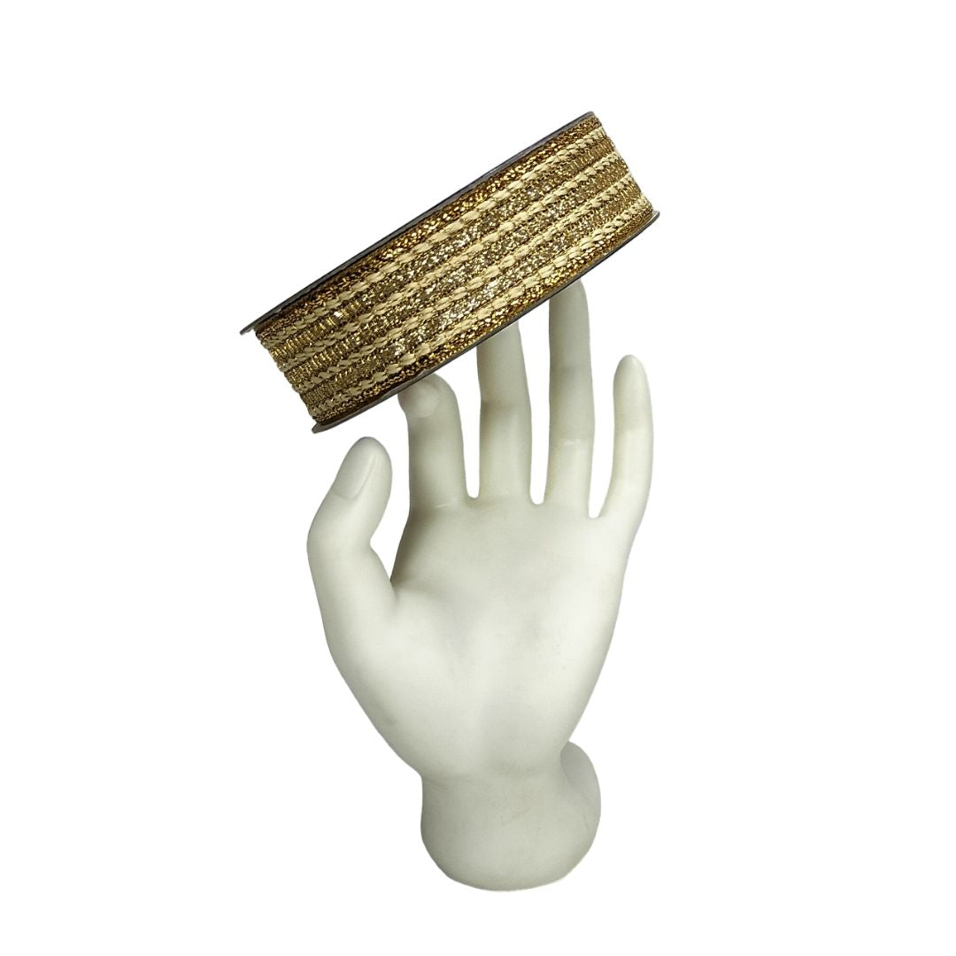 Gold bracelet on a white mannequin hand against a white background