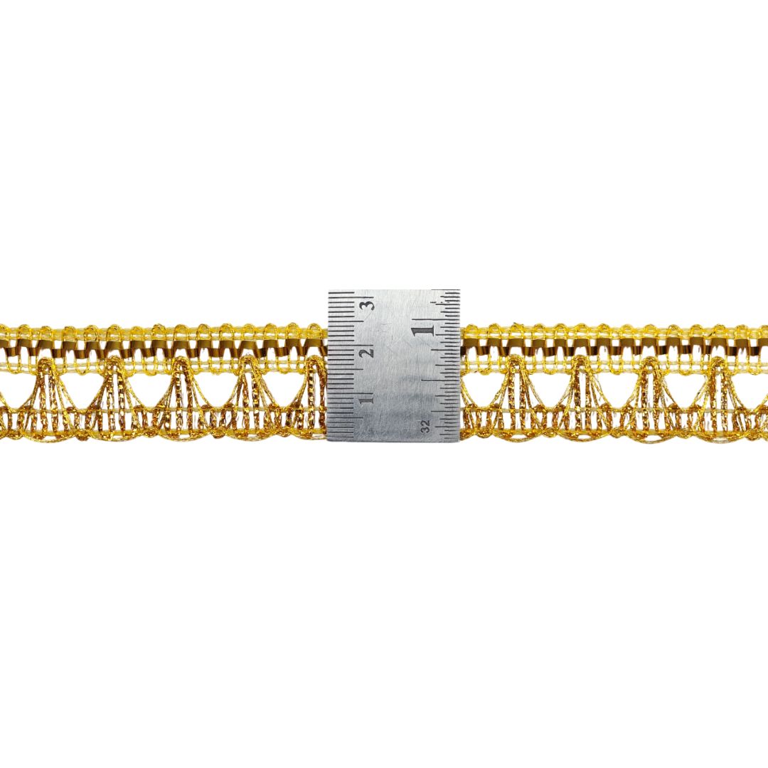 Gold lace trim with a ruler for scale on a white background