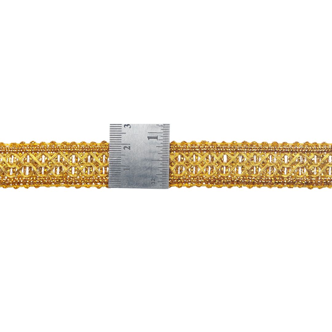 Gold lace trim with a ruler for measurement on a white background