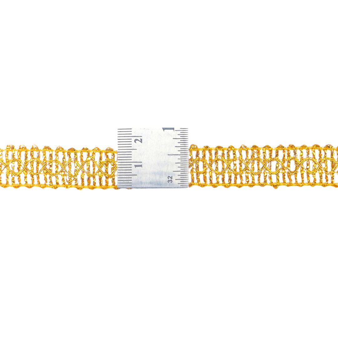 Gold lace trim with a ruler for measurement on a white background