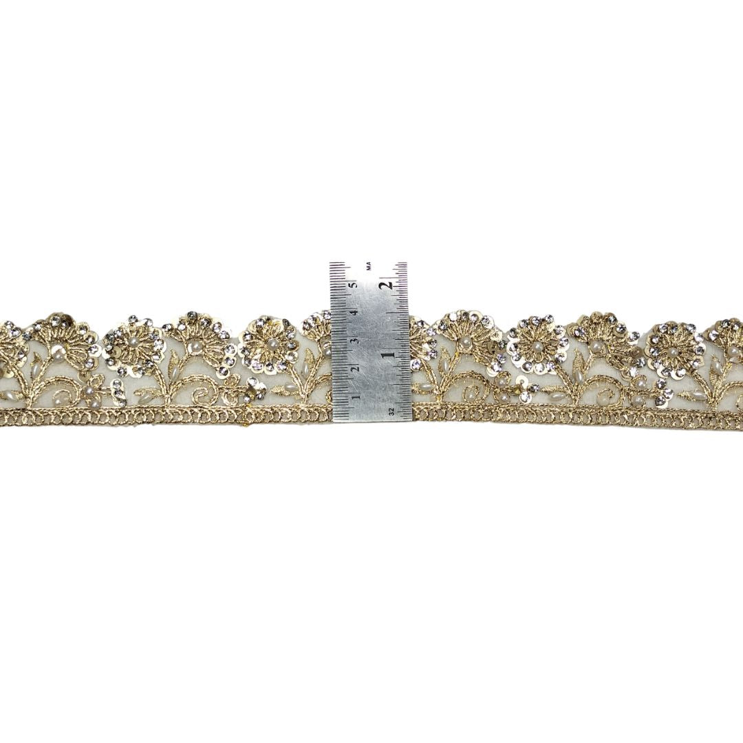 Decorative lace trim with a ruler for scale on a white background